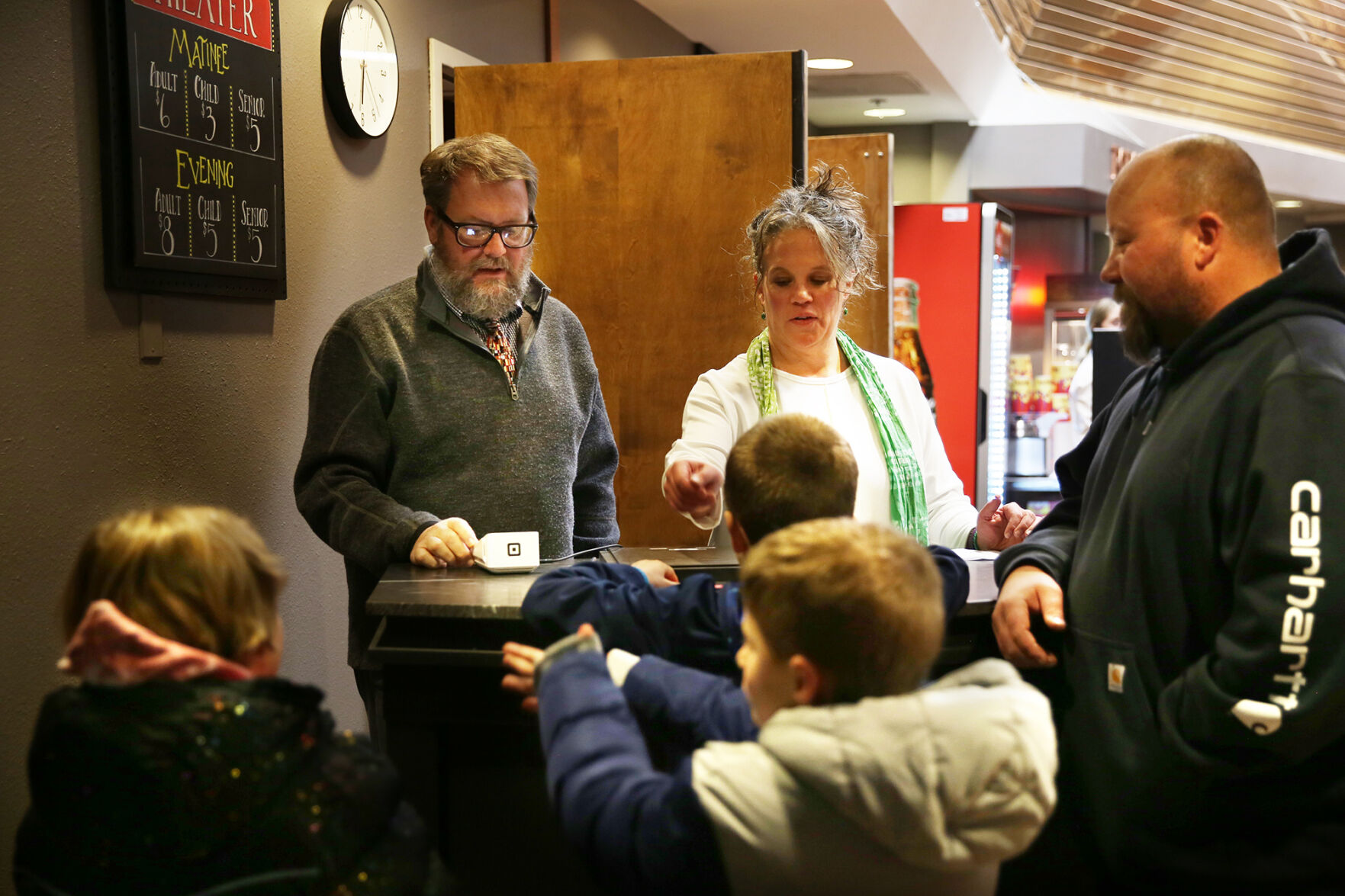 New theater owners Chris and Kira Wages hand tickets to a group of kids